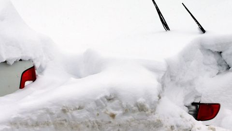 Dos vehculos cubiertos de nieve, en el pueblo asturiano de Pajares.