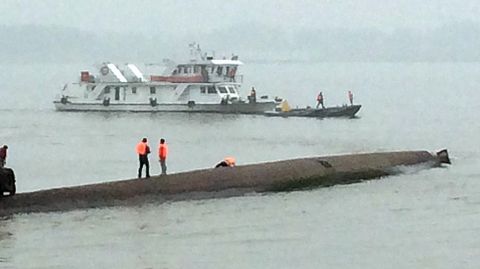 Hay rescatistas sobre la quilla del barco. Dentro se escuchan voces y ruidos. 