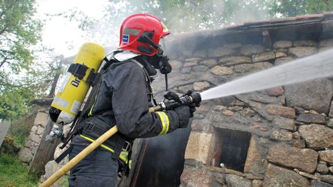 Una actuaci�n de los bomberos del parque de Monforte en el incendio de una bodega de la parroquia de Moreda, en una imagen de archivo