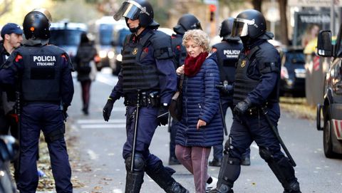 Los Mossos d'Esquadra retienen a una mujer por quemar ejemplares de la Constituci�n espa�ola en las calles de Barcelona, este jueves con motivo de la celebraci�n del 41 aniversario de la Carta Magna