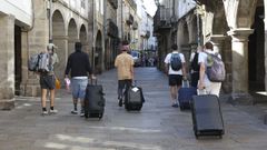 Un grupo de turistas porta sus maletas en el casco hist�rico de Santiago