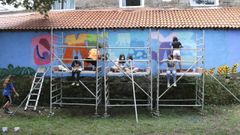 Participantes del taller dibujando las letras del mural en el r�o Gafo. 