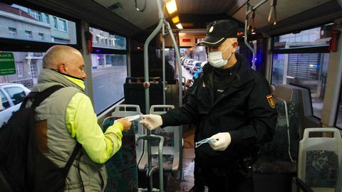 Policia local de Narn y Polica Nacional reparten mascarillas a usuarios del transporte pblico urbano en la carretera de Castilla en O Alto