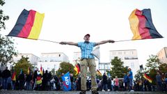 Un hombre enarbola banderas de Alemania en un acto de la campa�a electoral de AfD.