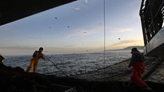 Imagen de archivo de dos pescadores de bajura ante la silueta de las islas C�es.