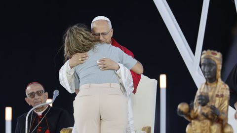 El papa Le�n XIV, acompa�ado por el cardenal Juan Jos� Omella (i), abraza a una mujer durante la vigilia que celebra con 40.000 personas este martes en el Estadio Ol�mpico de Barcelona.