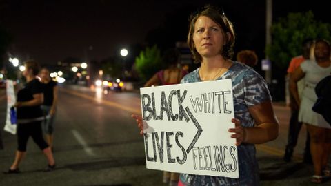 Una mujer porta una pancarta en la que se lee �Las vidas de los negros > los sentimientos de los blancos�.