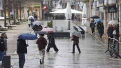 Los viandantes se protegen de la lluvia con paraguas en el barrio de A Magdalena de Ferrol