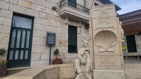 Escultura de un peregrino descansando ante el edificio de la Entidad Local Menor, realizada por Ralf Jung