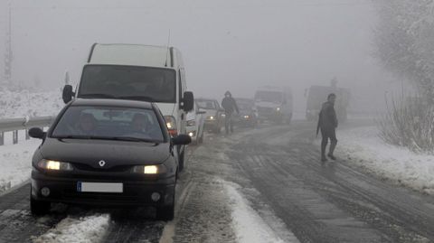 Coches parados en la carretera LU-546 entre el pueblo de Oural y la fbrica de Magnesitas de Rubin, en el municipio de O Incio