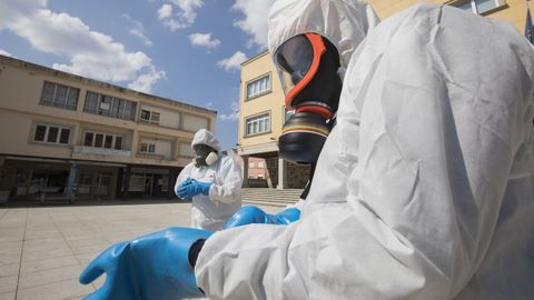 28 de marzo, d�a 14 de confinamiento. Mientras el balance de los muertos en Espa�a asustaba, con el mayor registrado hasta ese momento (un fallecido cada dos minutos), en todos los rincones de Galicia se luchaba por minimizar el contagio. En la imagen, miembros del equipo de limpieza se preparan para desinfectar la casa consistorial de Vimianzo.