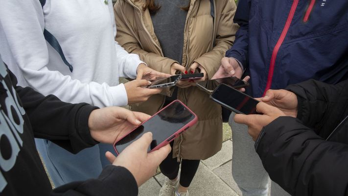 Varios j&oacute;venes muestras su m&oacute;vil en una imagen de archivo