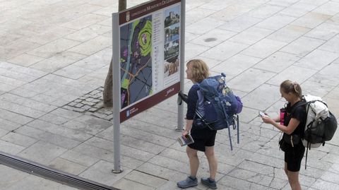 Dos peregrinas consultan un panel tur�stico en el casco hist�rico de Monforte