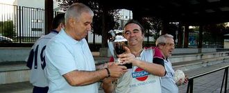 Germán Gamallo, del equipo del INSS, entrega el trofeo Perpetuo Socorro, al portero de O Chopo.