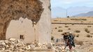 Una familia pasa junto a un edificio derruido en el cementerio de Amizmiz, a 50 kilmetros al sur de Marrakech