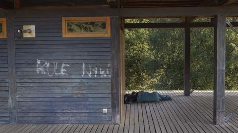 Un hombre dorm�a ayer en el exterior de la cafeter�a de O Restollal