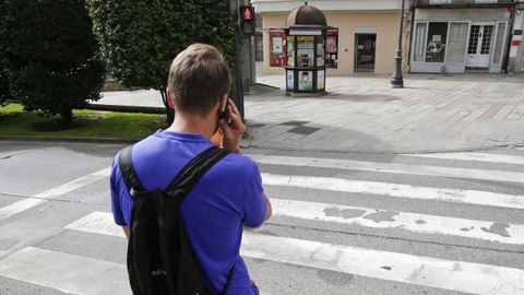 Imagen de archivo de un peat�n cruzando mientras habla por el m�vil.