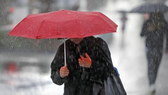 Imagen de archivo de una mujer paseando por la calle Urzaiz de Vigo bajo la lluvia.