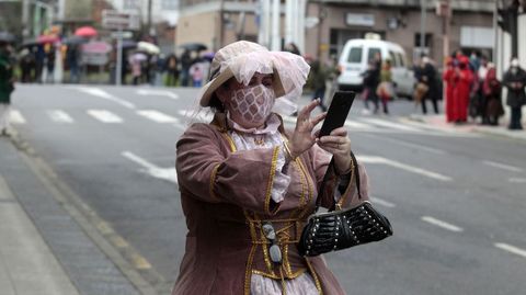 Una mujer disfrazada hace fotos de los participantes en el desfile en la plaza de A Florida