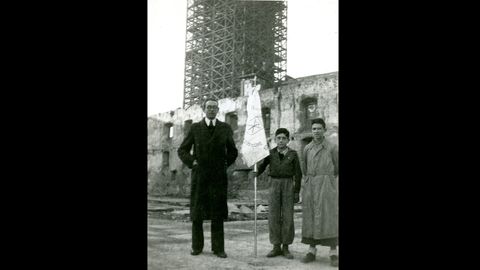 Bendici�n del bander�n de los aspirantes de Juventud de Acci�n Cat�lica de la parroquia de San Isidoro, Oviedo, en el solar del Palacio Episcopal incendiado durante la Revoluci�n de Octubre de 1934. Al fondo, la torre de la Catedral andamiada para su reconstrucci�n, el 6 de enero de 1944