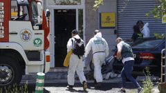Los expecialistas de criminal�stica de la Guardia Civil acceden al piso una vez que los bomberos extinguieron el incendio y se hall� el cuerpo de la madre