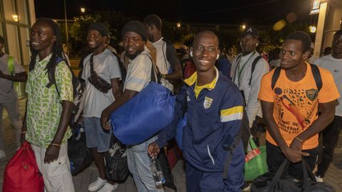 Los primeros inmigrantes, este martes por la noche en el Monte do Gozo, tras bajar del autobs que los trajo a Santiago.