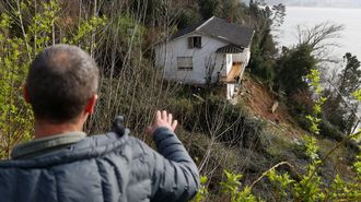 Eduardo R. Filgueiras, mirando el estado de su casa desde la finca de un vecino. 