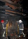 Tres bomberos trabajan en la casa tras apagar el fuego.