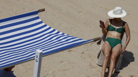 Mujer tomando el sol en la playa.