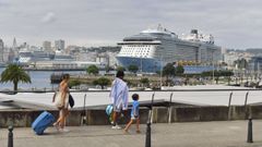 Una familia camina por O Parrote, con un crucero en el muelle de Trasatl�nticos