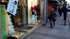 El �rbol navide�o comparte espacio con el cartel de rebajas en un escaparate de O Barco