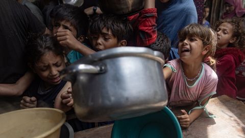 Un grupo de ni�os reclama su raci�n de comida en un comedor humanitario de Gaza