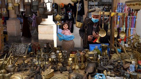 Un hombre con mascarilla en su puesto de venta en el mercado dominical de Oviedo