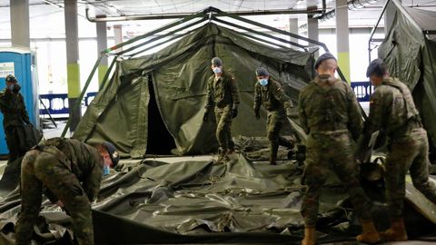 Soldados del regimiento de infanter�a n�mero 3 de la Brigada Galicia con base en Cabo Noval durante el repliegue parcial de la estaci�n de triaje instalada por el ej�rcito en uno de los aparcamientos del Hospital Universitario Central de Asturias (HUCA)