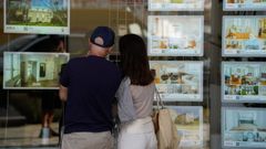 Imagen de archivo de una pareja viendo el escaparate de una inmobiliaria