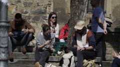 Varias personas toman el sol en una plaza de Cimavilla