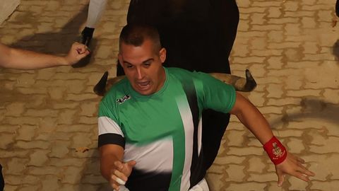 Un mozo perseguido por uno de los toros de la ganader�a gaditana de La Palmosilla a su paso por el callej�n 