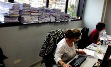 Dos funcionarias de la oficina de reparto registran la entrada de una monta�a de demandas de Civil