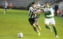 Joselu es sujetado por un rival en el partido frente a los asturianos. 