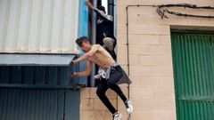 Dos menores migrantes escapando hoy de la nave ceut� del Tarajal donde eran atendidos