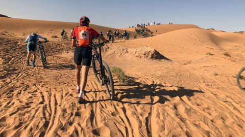 Pablo Antu�a empuja su bicileta sobre la arena de Marruecos en una de las etapas de la Titan Desert