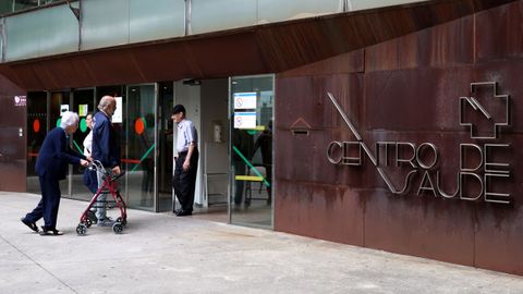 Varias personas entrando y saliendo del centro de salud Rosal�a de Castro, en Vigo.