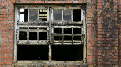 Ventanas rotas y ya casi sin cristales en uno de los edificios de la antigua fbrica de Cermicas El Castelo, de Monforte