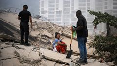 Una mujer sobre las ruinas de un edificio residencial en La Guaira.