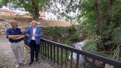 Jos Antonio Quiroga (a la izquierda) y Jos Tom en la pasarela peatonal que ser sustituida por un nuevo puente sobre el arroyo de Rioseco. Al fondo, el muro de contencin recin reparado