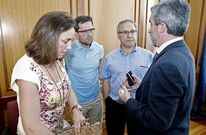 El alcalde (derecha) departe con los portavoces municipales antes de un pleno.