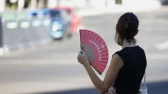 Una joven se abanica y se refugia del calor en Madrid