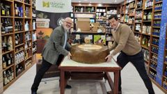 Jos� Antonio Blanco (izquierda) y Jes�s Oroza, clientes de Bodegas Barral, amagan con levantar la pieza de 130 kilos