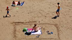 Varias personas disfrutan de un soleado d�a de verano en la playa de San Lorenzo en Gij�n,