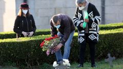 Varias personas con mascarilla visitando el cementerio de Pereir�, en Vigo